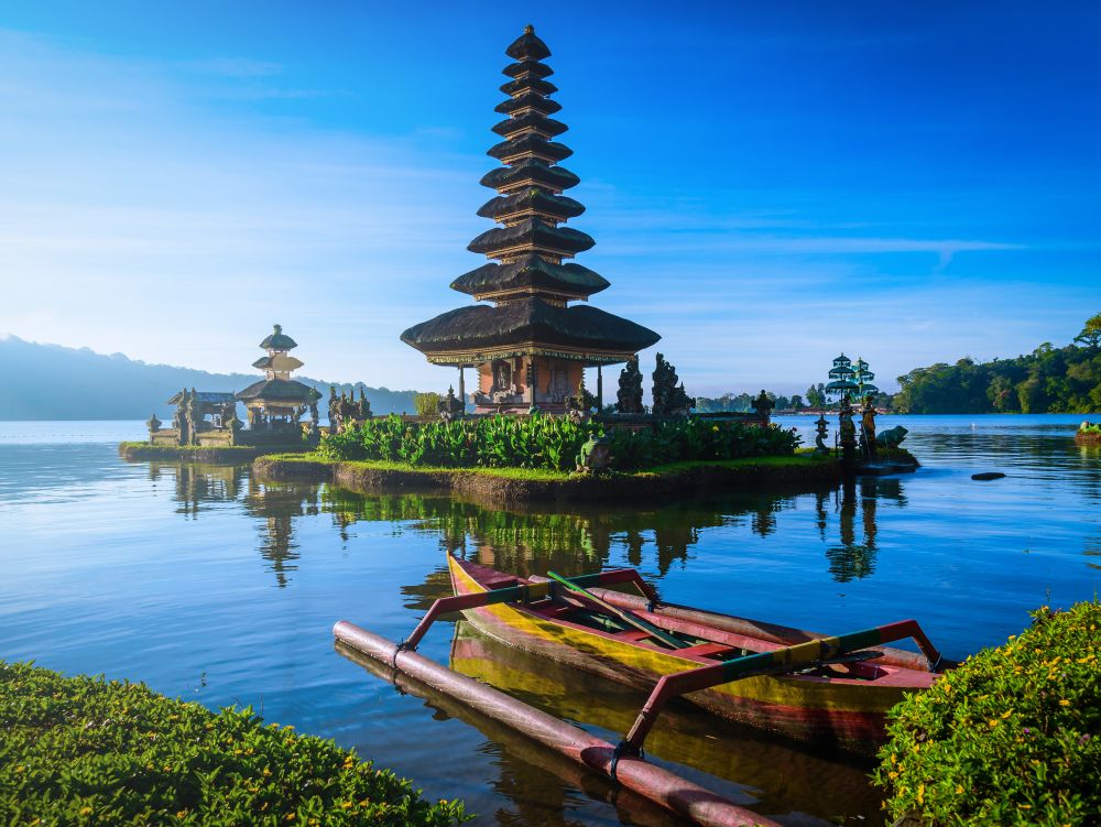 Pura Ulun Danu Bratan, Hindu temple with boat on Bratan lake landscape at sunrise in Bali, Indonesia.