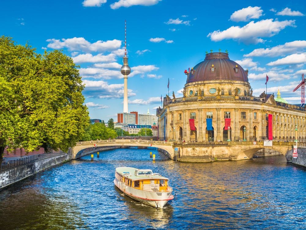 Museumsinsel with TV tower and excursion boat on Spree river at sunset, Berlin, Germany